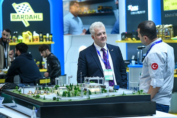 Two attendees discuss a scale model