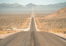 Reclaimed Fill, Recycled Asphalt and the Future of Sustainable Road Construction Long straight road stretches through a desert toward distant mountains under a clear sky.