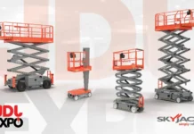 Skyjack Showcases Newest Slab and Rough Terrain Scissor Lifts at 2026 JDL Expo in France Group of red Skyjack scissor lifts of varying heights on a showroom floor with JDL Expo branding in the corner.